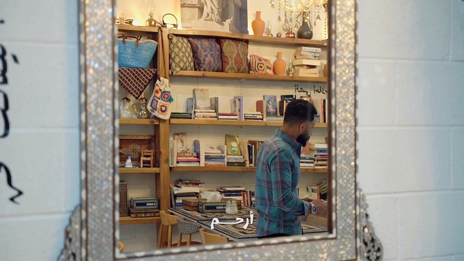 In the mirror by the shelves
