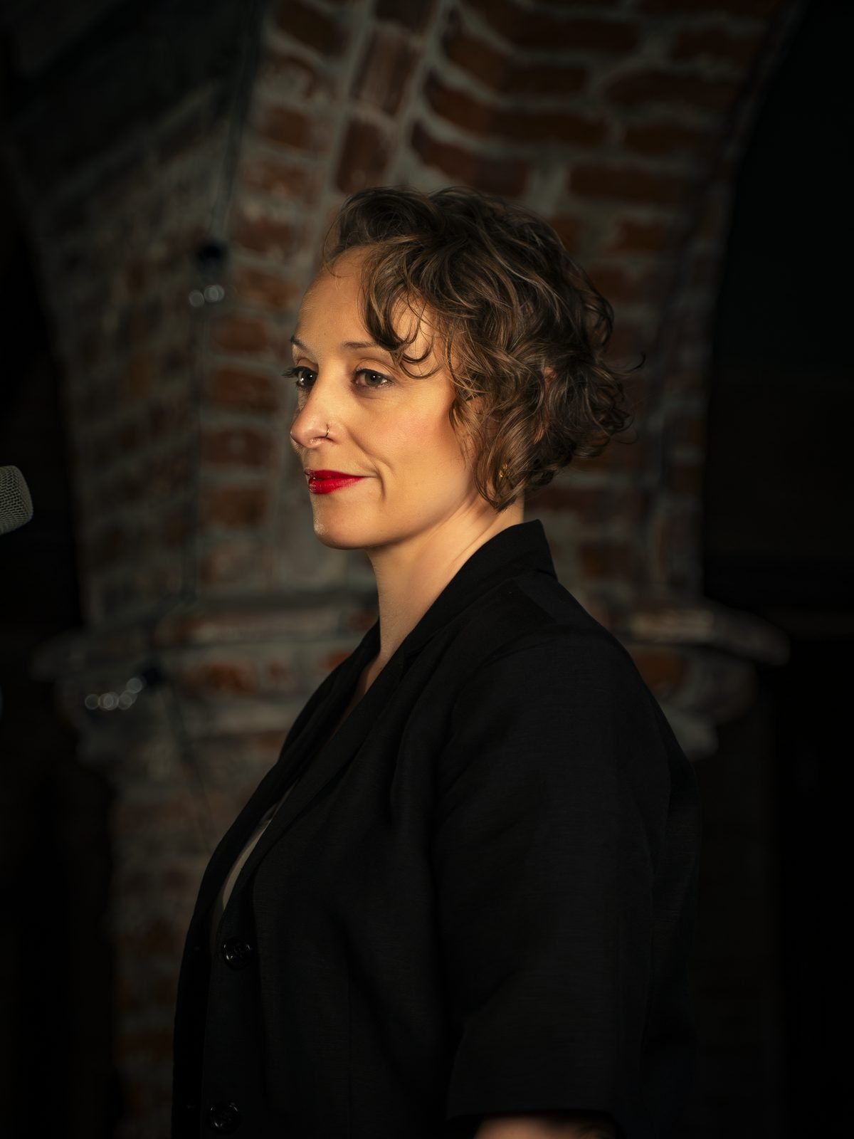 The singer in a black jacket against the brick