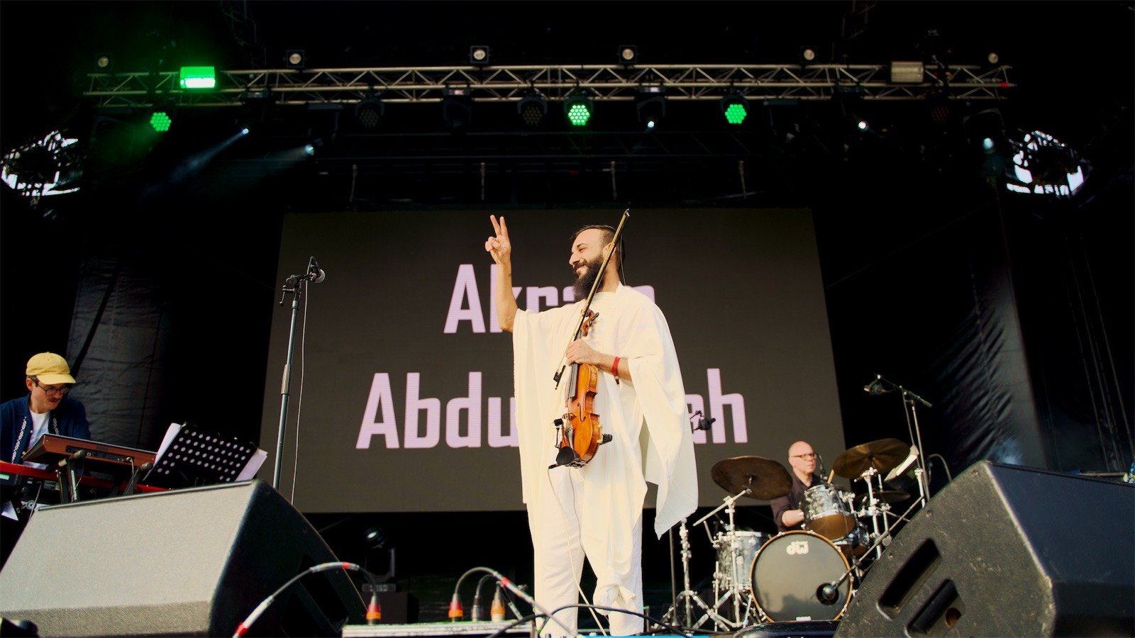 A peace sign to the crowd, violin in hand