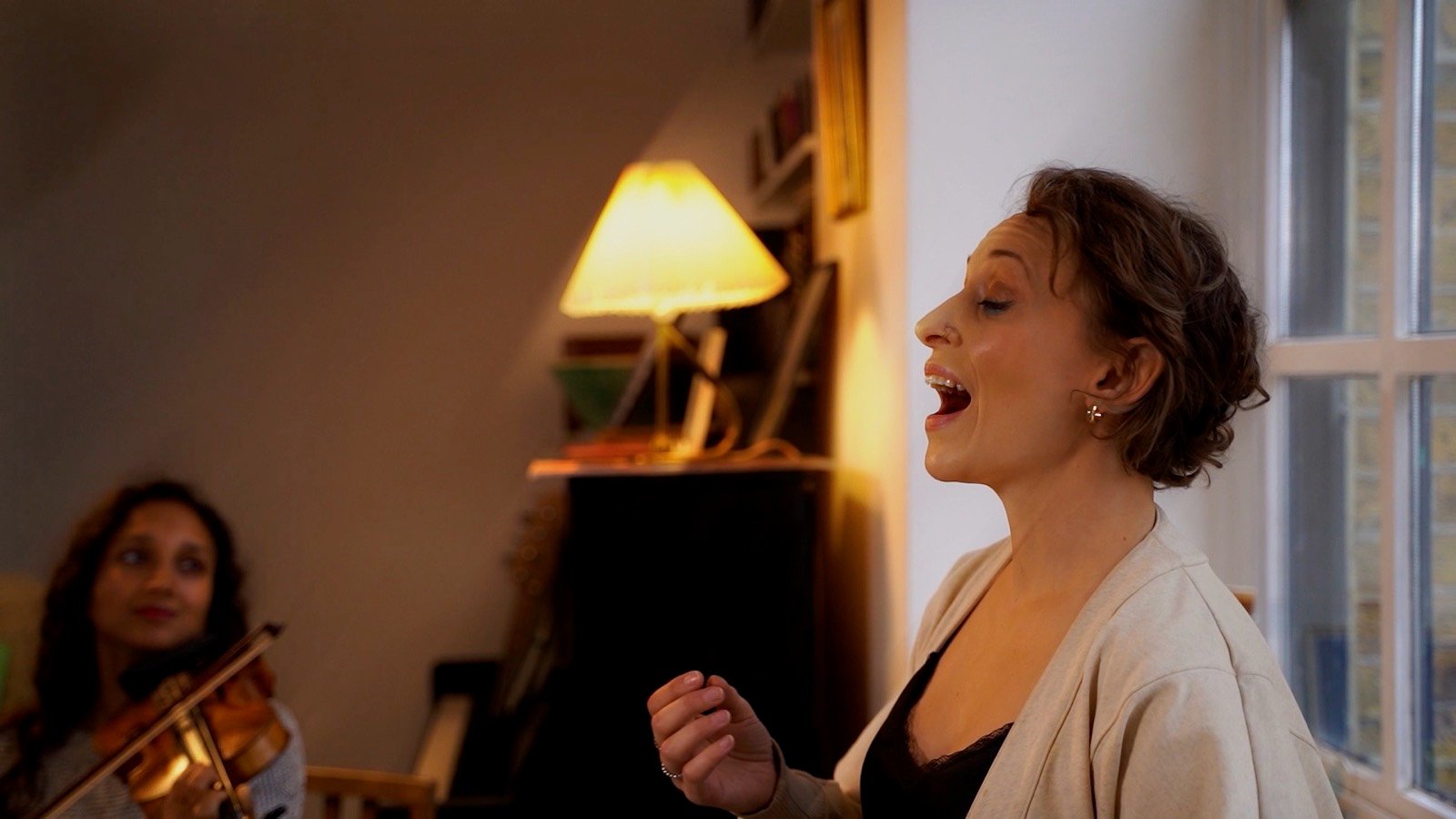 Singing, with the violin behind