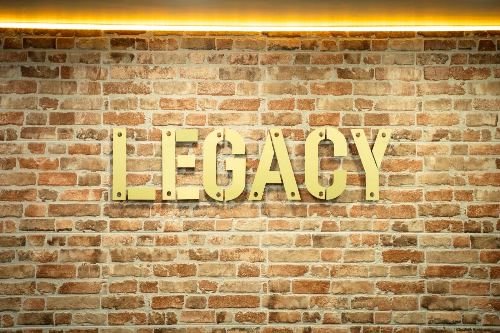 The gold Legacy sign on brick