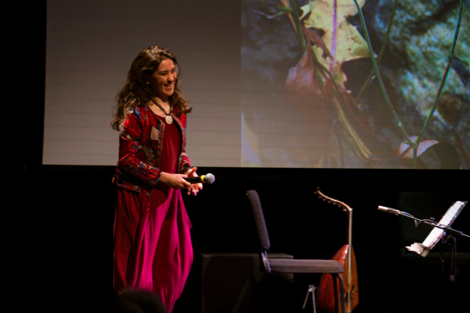 At the microphone, the screen behind