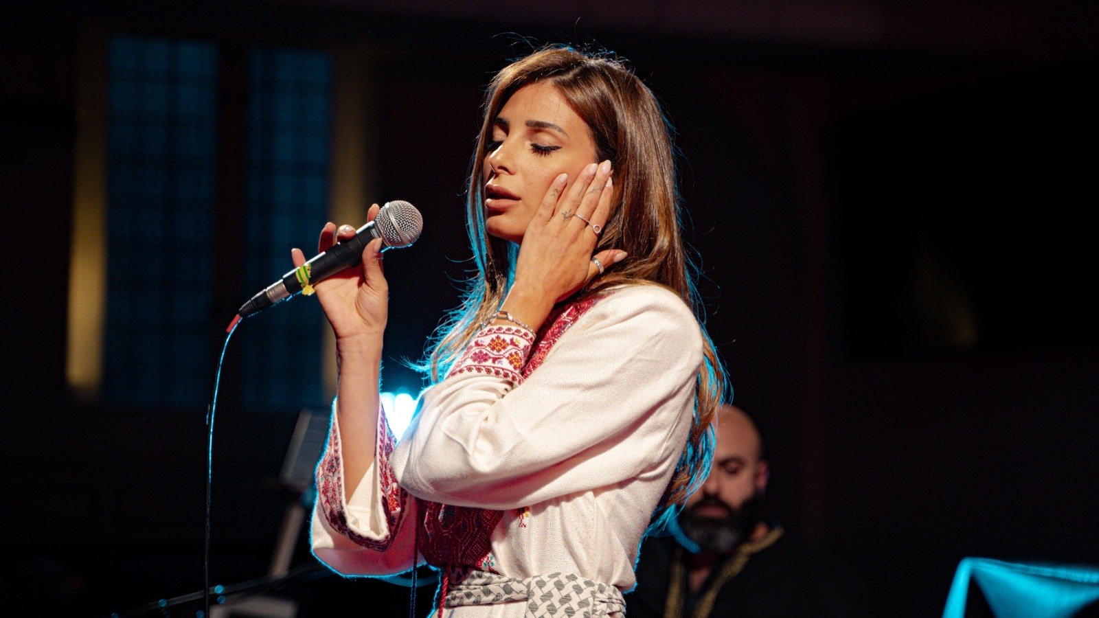 A hand to her ear, mid-song