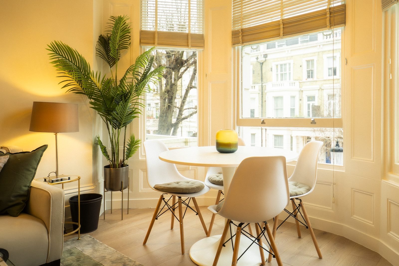 A round dining table in a bay window in Earl’s Court