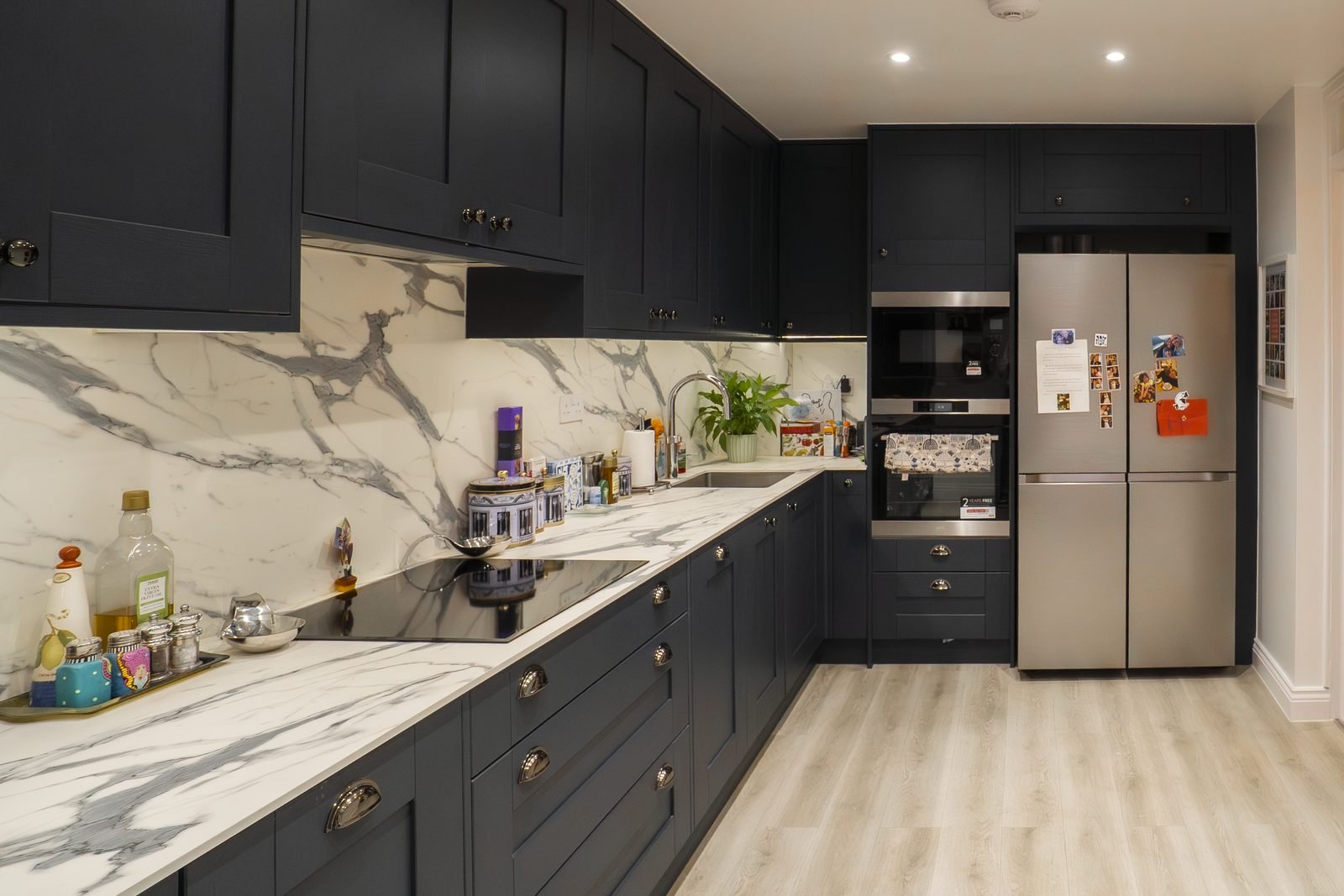 A marble worktop running along a navy kitchen in Edgware