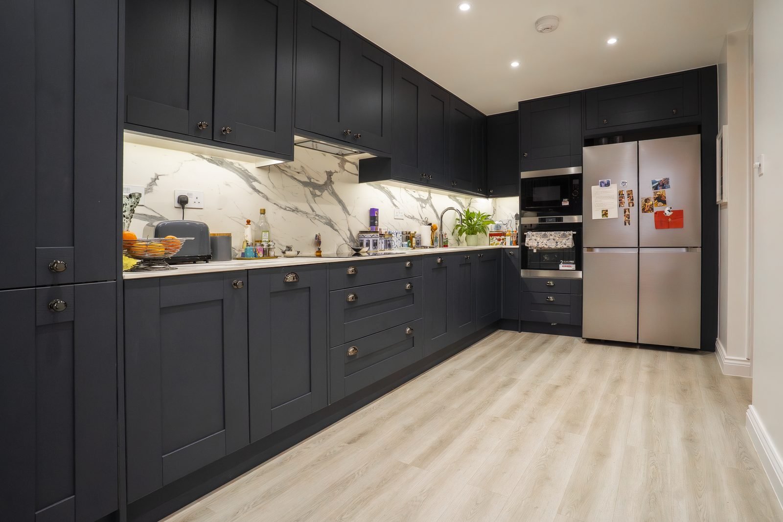 A navy kitchen with a marble splashback in Edgware