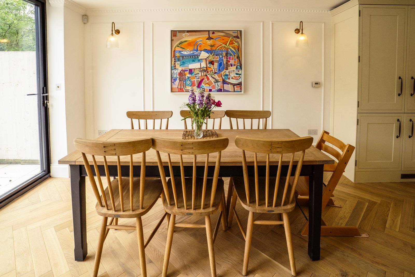 A long dining table with spindle-back chairs