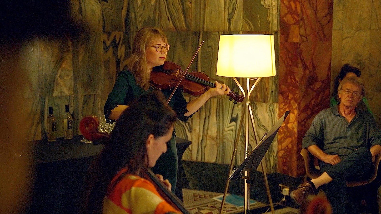 A listener beside the violinist