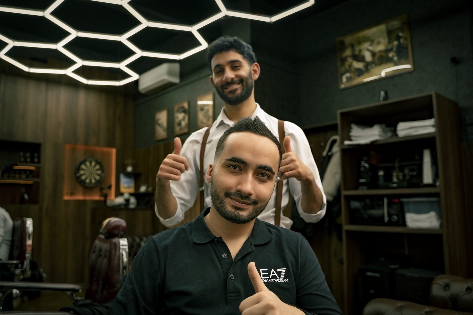 A barber and his client giving a thumbs up