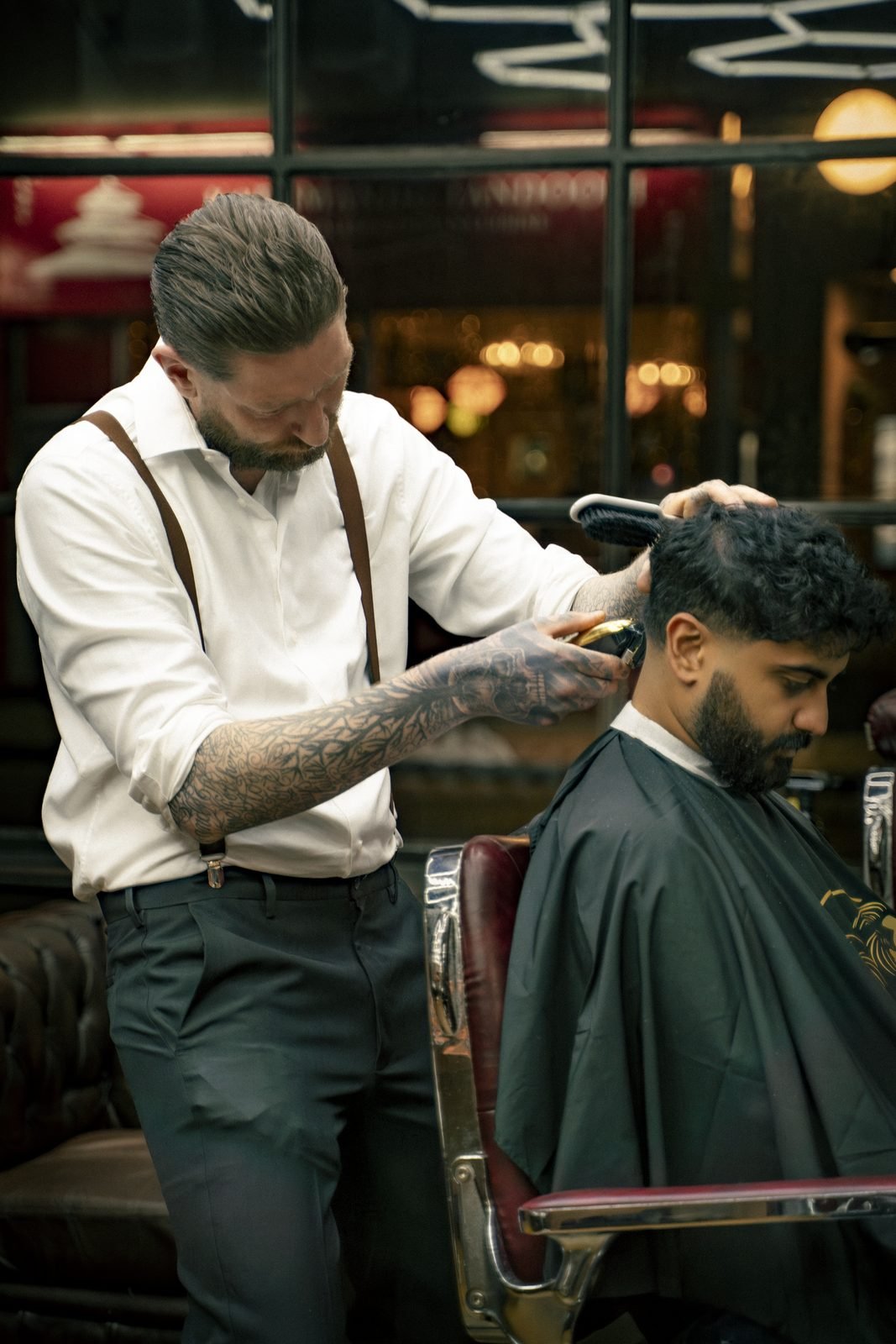 A barber trimming a client’s hair