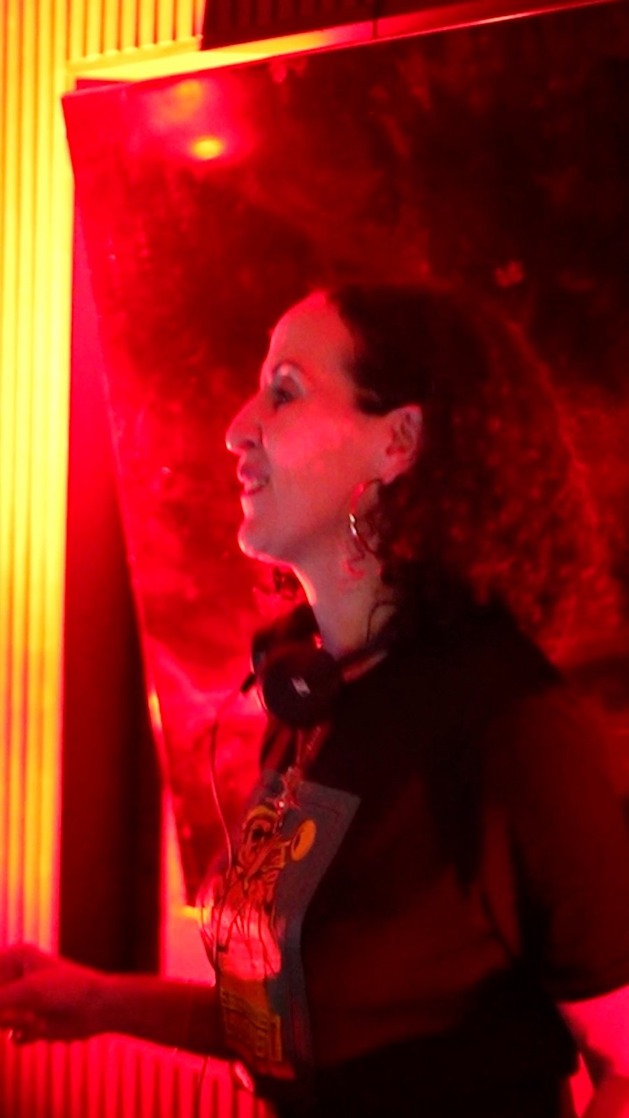 A woman lit red on the dance floor of a club night