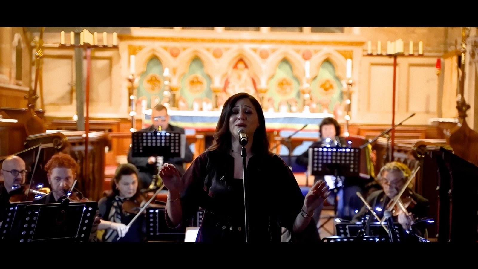 A singer in front of a chamber orchestra in a church